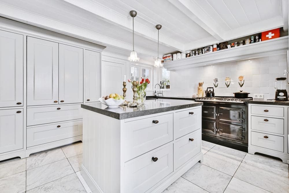 Bright, medium sized kitchen with white cabinets and an island