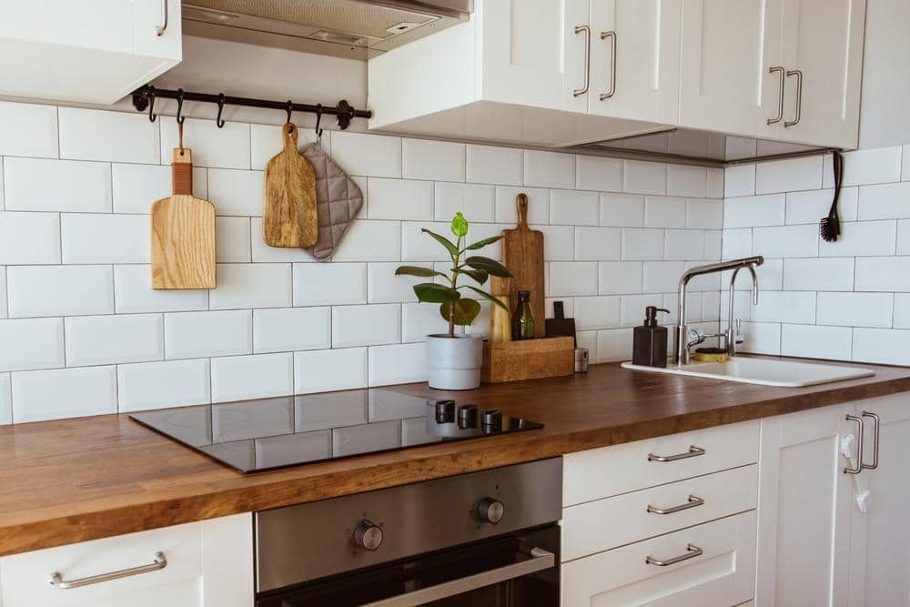 kitchen wooden counter with stove and oven and has white brick wall