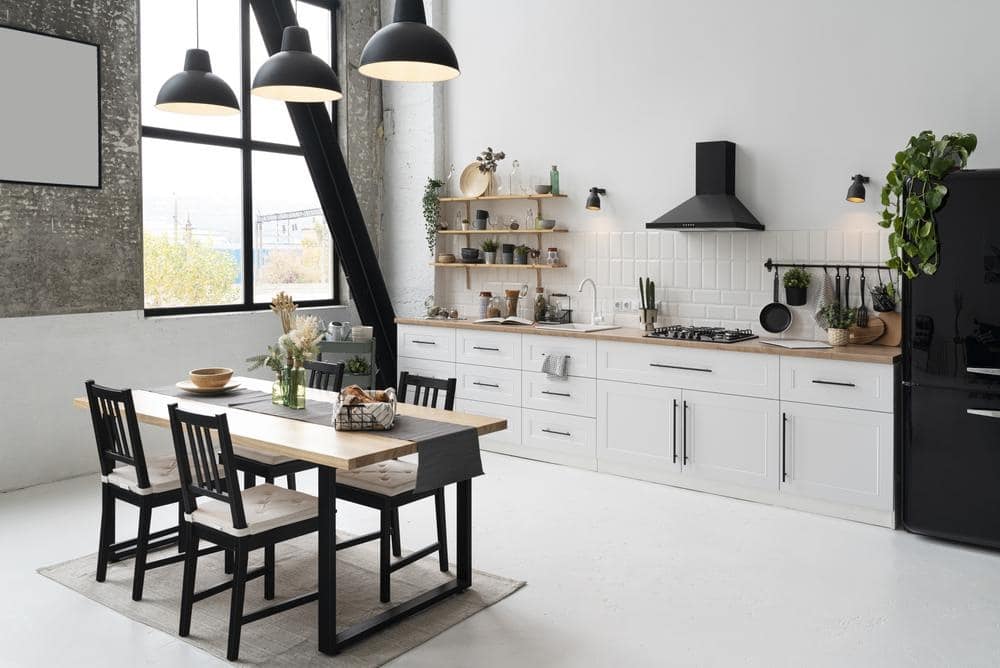 modern white kitchen with black furniture and fridge and large black framed window
