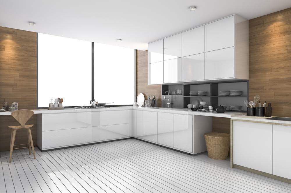 modern handleless kitchen cabinets in white kitchen with large windows and wooden wall decor