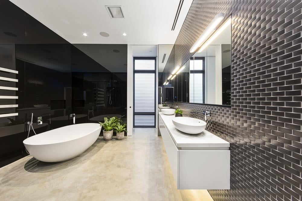 bathroom with black walls and wooden floor and standing bath tub