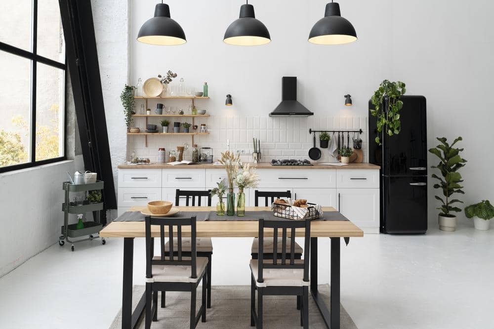 white kitchen with cabinets and black pendant lighting hanging from ceiling