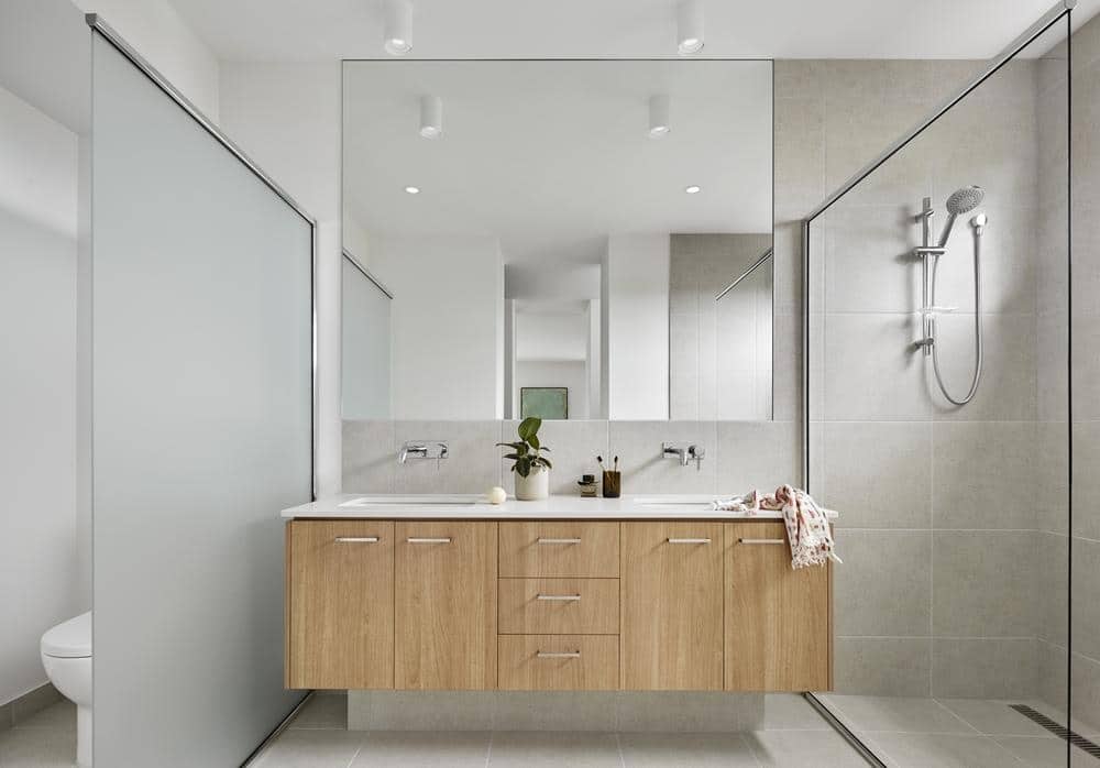 small bathroom with wooden vanity and large wide mirror