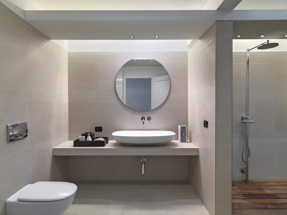 modern grey bathroom vanity with lighting and round mirror