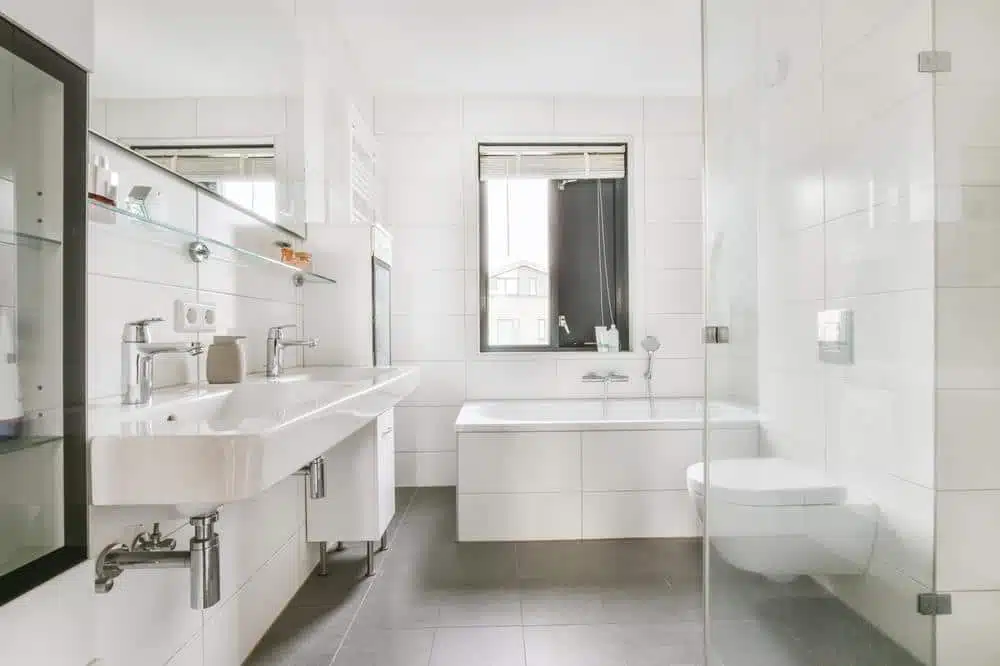 white bathroom with hanging toilet and a bathtub