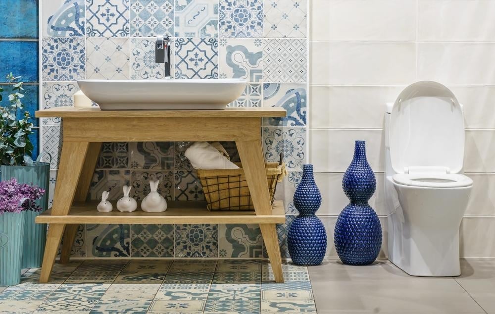 bathroom with wooden vanity and a white sink with blue tiles
