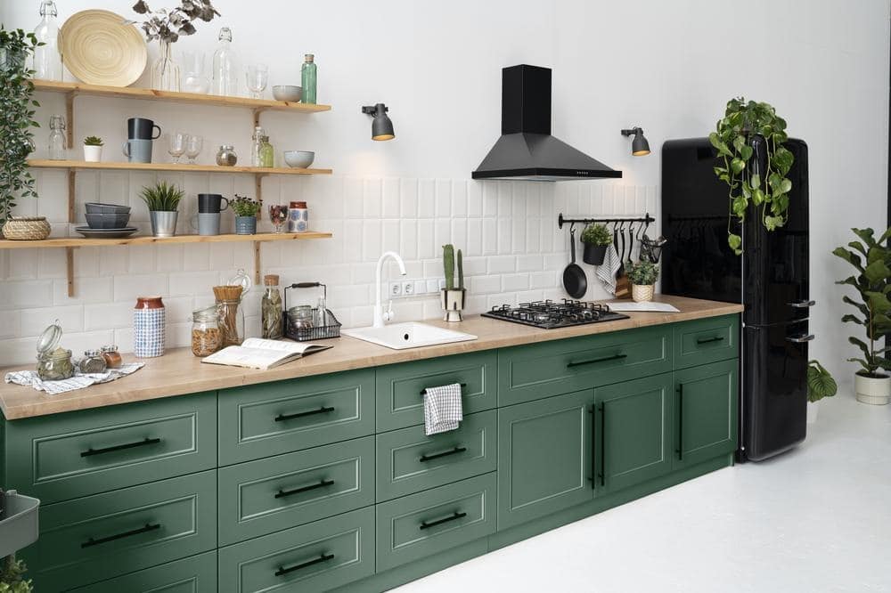 kitchen counter with green cabinets and drawers with white backsplash