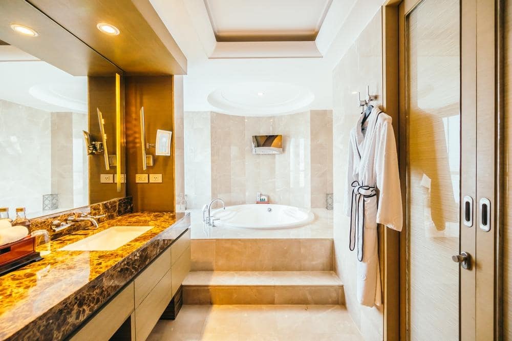 marble shining modern bathroom with bathtub and vanity