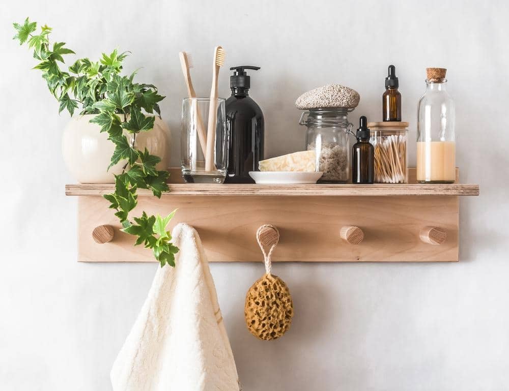 wooden hanger with a shelf with bathroom utensils
