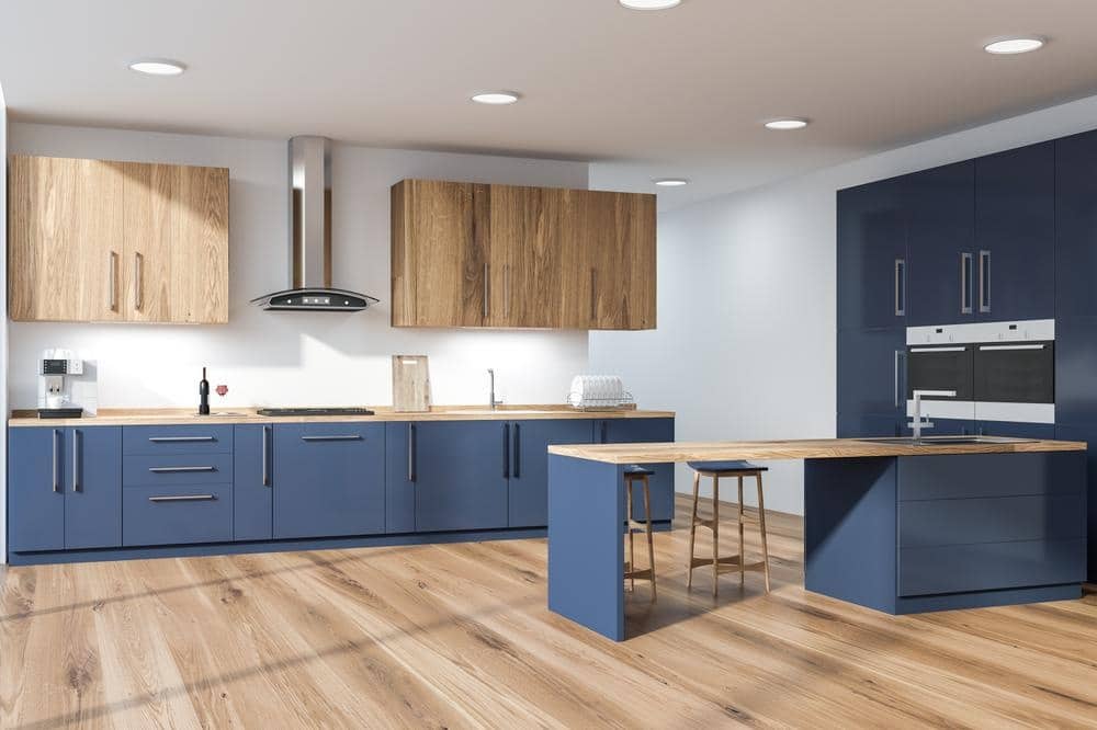 corner stylish kitchen with white walls wooden floor blue countertops with built sink cooker wooden cupboards blue cupboard with ovens blue wooden bar with stools 3d rendering | 12 Fresh Blue Kitchen Cabinets Ideas - Reviving Your Kitchen Space